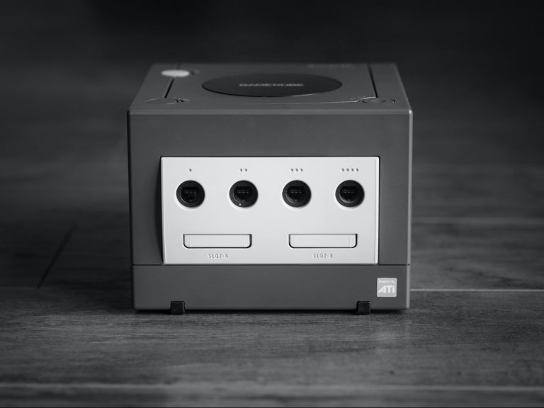 white and black Nintendo GameCube on gray surface