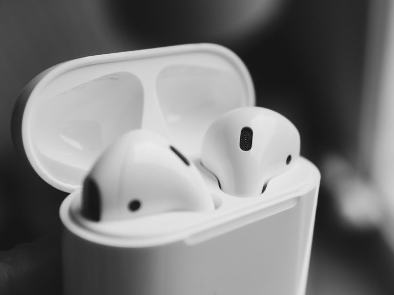 macro photography of wireless earbuds in charging case