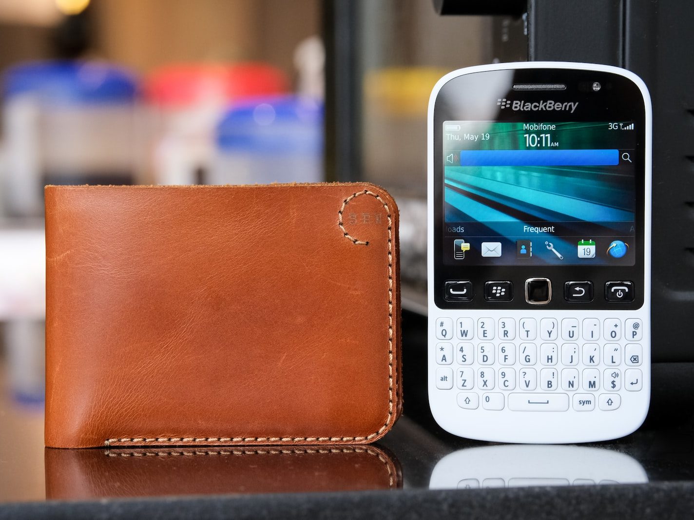 a cell phone sitting next to a wallet