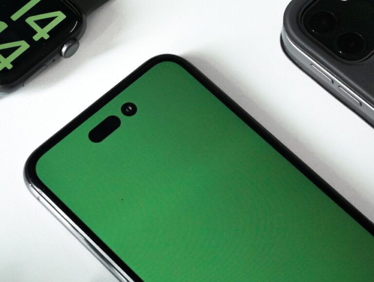 an apple watch with a green screen next to an iphone