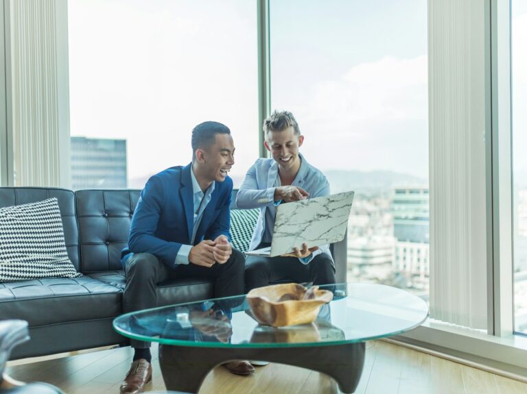 two men in suit sitting on sofa