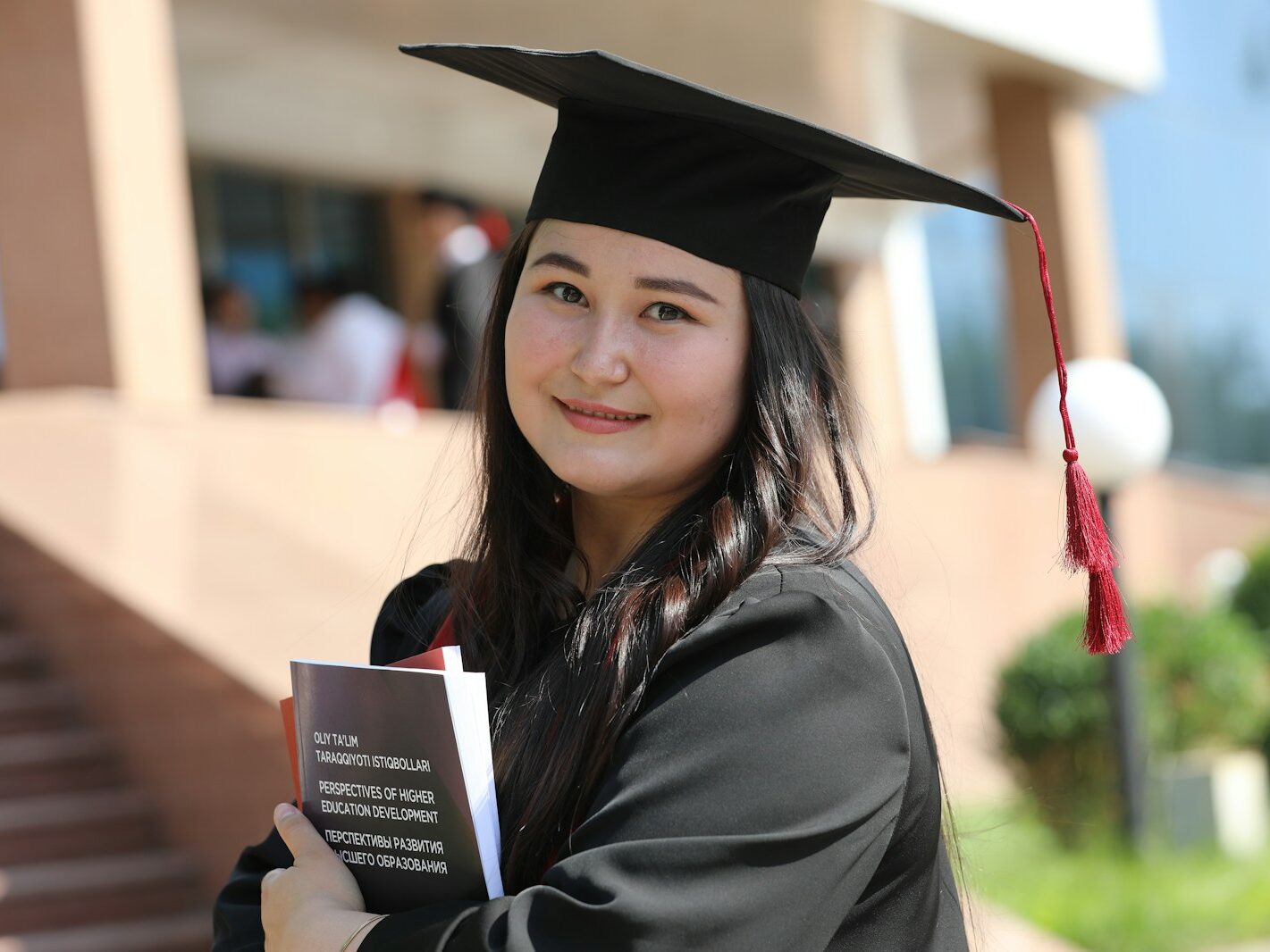 a woman in a graduation gown holding a book