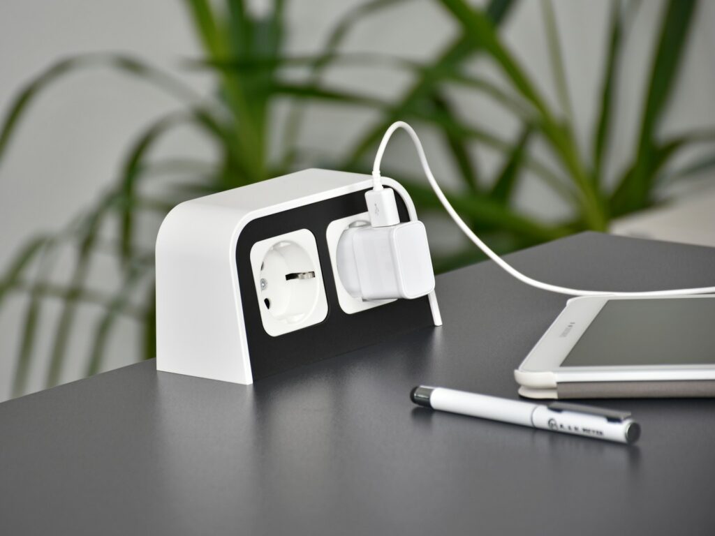 an electronic device charging on a table next to a cell phone