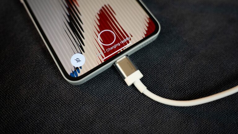 A phone is charging with its cable.